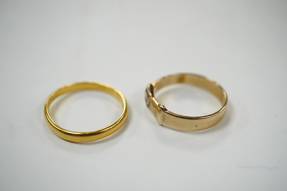 A modern 9ct gold buckle ring, 2.2 grams and a 22ct gold wedding band, 1.6 grams. Condition - poor